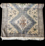 Elegante tapete paquistanês Karachi, tecido à mão em lã sobre base de algodão, caracterizado por sua composição clássica em três medalhões centrais losangulares, emoldurados por uma borda ornamental de inspiração floral e geométrica. A paleta suave combina tonalidades de bege, verde, azul e acentos terrosos, conferindo à peça um aspecto tradicional e harmonioso.  (Apresenta alguns desgastes). Dimensões: 1,60x0,93.