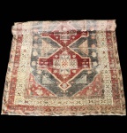 Imponente tapete Kazak turco, reconhecido por sua estética tribal geométrica e pela forte presença visual dos seus grandes medalhões centrais escalonados, típicos das tecelagens do leste da Anatólia. A peça apresenta três medalhões interligados em tons de vermelho profundo, azul petróleo e cinza, com elementos simbólicos como cruzes estilizadas, ganchos, estrelas e formas angulares, todos característicos da iconografia Kazak. A paleta desbotada pelo tempo  com nuances de marfim e terracota  reforça seu caráter autêntico e artesanal.A borda múltipla combina padrões geométricos repetitivos, criando um enquadramento forte e harmonioso. Tecida à mão em lã sobre urdume de algodão, a peça mantém as proporções e o estilo robusto que diferenciam os Kazak turcos de outras tradições caucasianas. Apresenta desgaste natural e variações de cor compatíveis com sua idade, preservando, porém, a estrutura e a leitura do desenho. Dimensões: 2,94x1,66