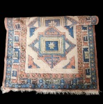 tapete Kazak, reconhecido por seus motivos tribais geométricos e pela presença marcante de medalhões centrais estilizados. O campo apresenta repetição de formas angulares e estrelas tradicionais, dispostas de forma simétrica e profundamente enraizadas na estética caucasiana que inspira os Kazak clássicos. A paleta é composta por tons de vinho, terracota, marfim, azul profundo e detalhes em preto, criando um contraste forte e característico desse estilo. A borda múltipla exibe padrões geométricos em sequência, reforçando o caráter tribal e a sensação de movimento. Tecida à mão em lã sobre base de algodão, a peça demonstra boa estrutura e equilíbrio visual. Apresenta desgaste natural e variações de tom, resultantes do uso e do tempo, preservando, porém, sua integridade decorativa e autenticidade. Dimensões: 1,82x1,26.