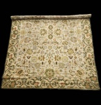 Tapete português de Arraiolos, execução artesanal em lã sobre base de juta, apresentando desenho clássico de influência indo-persa.A peça exibe campo central amplo em tonalidade cru, ricamente preenchido por composição vegetalista simétrica, com flores, palmetas, ramos entrelaçados e arabescos estilizados, trabalhados em paleta suave de verdes, ocres, dourados e terracotas. A cercadura larga, em verde musgo, destaca-se pelo motivo contínuo de volutas e elementos florais, característica recorrente nos melhores trabalhos alentejanos.Trabalho tradicional de Arraiolos, de grande presença decorativa, revelando equilíbrio cromático e leitura elegante do repertório ornamental clássico. Apresenta algumas desgastes do tempo. Dimensões: 4,00x 3,00