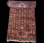 Tapete persa Hamadã, trabalho artesanal em lã sobre algodão, no formato runner.Apresenta campo densamente ornamentado por motivo repetitivo de inspiração herat, em fundo vermelho profundo, com detalhes em verde escuro, marfim e preto. Ao centro, destaca-se medalhão floral em marfim, que dá equilíbrio ao desenho contínuo. A cercadura tripla reúne elementos florais e geométricos característicos das aldeias da região de Hamadã, reconhecidas pela resistência da lã e pela robustez da fatura.Peça de composição tradicional, com uso marcante de tonalidades quentes e leitura decorativa elegante. Apresenta rasgo em uma das extremidades. Dimensões: 3,07x0,82