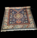 Belo exemplar de tapete caucasiano Shirvan (Chirvan), execução manual em lã sobre algodão.Exemplar de forte caráter tribal, apresentando três medalhões geométricos centrais em azul, amarelo e vermelho, dispostos sobre campo azul-noite densamente preenchido por rosetas, elementos angulares, pequenos animais e motivos simbólicos típicos do leste do Cáucaso. A cercadura múltipla reúne frisos geométricos estreitos e borda principal em fundo marfim, decorada por motivos em S e ganchos caucasianos, em paleta vibrante de azuis, laranjas e terracotas. Peça de desenho vigoroso e excelente leitura cromática, com áreas pontuais de desgaste na extremidade inferior, sem comprometer a integridade geral nem o valor decorativo e etnográfico. Apresenta desgaste natural do tempo.  Dimensões:3,20x1,96.