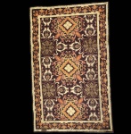 Tapeçaria Casa Caiada intitulada Flor dos Montes, execução artesanal em lã sobre base têxtil, datada de 1979.A composição apresenta desenho geométrico-floral simétrico, característico da produção da Casa Caiada, com paleta quente em tons de marrom, ocre, âmbar e laranja. O motivo central se repete em módulos equilibrados, enquadrados por cercadura decorada com friso de folhagens estilizadas. No verso, inscrição original Flor dos Montes  1979, identificando título e procedência da peça. Dimensões: 1,25x0,80