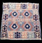 Kilim persa, trabalho artesanal em lã sobre algodão.Apresenta composição geométrica típica dos kilims tribais, com campo estruturado em faixas horizontais que alternam motivos romboidais, ganchos estilizados e padrões em zigue-zague. A paleta suave, em tons de azul, rosa antigo, creme e azul-marinho, confere leveza ao desenho e reforça o caráter decorativo da peça. A técnica plana (flat weave) evidencia a precisão das linhas e a clareza dos motivos tradicionais da tecelagem persa.Exemplar de boa presença visual, representativo dos kilims do Irã, valorizados pela simplicidade geométrica e harmonia cromática. Dimensões: 1,22x1,26