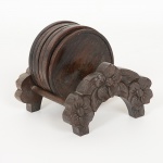 DIVERSOS, conjunto porta copos com sete (7) itens: 1 suporte com entalhe floral e 6 bolachas torneadas, todosconfeccionados em madeira, ebanizados, medindo respectivamente 11 x 11 x 7 cm e 9 cm diâmetro, sinais de uso, videfoto.