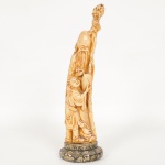 ESCULTURA, uma (1) representando o Deus FUKUROKUJU, segundo o Xintoísmo, Mitologia e Folclore Japonês,Deus da longevidade e sabedoria, representado por uma longa barba branca trazendo na mão um cetro ou bastão (saku)sagrado onde esta pendurado um pergaminho (makimono) contendo as escritas da sabedoria mundial, considerado Deusda ecologia, as vezes acompanhado por um veado, tartaruga ou uma garça tipo grou (tsuru), outras vezes de um pêssego,ter sua estatueta traz popularidade e garante longevidade, integrante do Shichi Fukujin (os 7 Deuses da Boa Sorte,Fortuna e Felicidade), confeccionado em estuque, encontra-se de pé ao lado de uma criança, extremidade quebrada ecolada, tonalidade marfim, medindo 31,5 cm altura, vide foto.