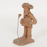 ARTE POPULAR, uma (1) escultura representando sanfoneiro, arte figurativa da região do Alto do Moura, Caruaru,PE, modelada em barro e cozida, assinada em cavo MANUEL ANTÔNIO (contemporâneo de Mestre Vitalino),medindo 12,5 cm altura, vide foto.