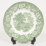 FAIANÇA INGLESA, um (1) prato ornado com cena rural na tonalidade verde, borda em elementos vegetalistas,manufatura Wedgwood & Company (fundada em 1860 por Enoch Wedgwood, primo distante de Josias Wedgwood I;em 1986 a Wedgwood foi vendida para Waterford Glass Group), selo da DROHAOSER (Comercio e Industria S/A),medindo 25,5 cm diâmetro, sinais de uso, vide foto.