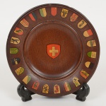 SOUVENIR, um (10 pratinho para fixação em parede, ornado com Brasões das Cidades Suíças em policromia,confeccionado em madeira torneada, medindo 12 cm diâmetro, vide foto.