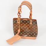 ACESSÓRIO FEMININO, uma (1) bolsa confeccionada em polímero transparente, arremates em couro e metal,marca LOUIS VUITTON, Paris, Made in France, bolsa interna com parte do zíper partido, medindo 28 x 23 x 10 cm,sinais de uso, vide foto.