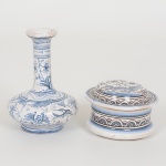 FAIANÇA PORTUGUESA, dois (2) itens: 1 pequeno vaso com ornamentação pintada a mão na técnica blue andwhite, representando castelo e elementos vegetalistas, baseado em cerâmica de Coimbra do século XVII, medindo 9,5cm altura; 1 pote com tampa na mesma padronização, representando animal e elementos vegetalistas, medindo 7 cmdiâmetro, sinais de uso, vide foto.