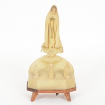 ARTE SACRA, uma (1) imaginária representando a Aparição de Nossa Senhora de Fátima, possui dispositivomusical emperrado, confeccionado em polímero e outros materiais, medindo 16,5 cm altura, vide foto.