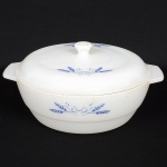 VIDRO, uma (1) saladeira com tampa, tonalidade branca, opalinada e leitosa dita milk glass, singela ornamentaçãoem feixe de trigo na tonalidade azul, marca COLOREX, medindo 23 cm diâmetro mais as alças, sinais de uso, vide foto.