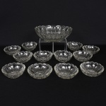 VIDRO, conjunto com treze (13) itens, incolores e translúcidos: 1 saladeira e 12 taças, modelados em gomos, fundoestrelado, medindo respectivamente 25 cm e 11 cm diâmetro, sinais de uso, vide foto.