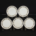 PORCELANA, cinco (5) pratos para sobremesa, um deles com bicados na borda, ornado com faixas intercaladasna tonalidade azul, volutas em amarelo, frisos prateados já com sinais de desgastes, manufatura STEATITA (CampoLargo, PR, funcionou de 1954 a 1994), medindo 19 cm diâmetro, sinais de uso, vide foto.