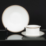 PORCELANA, dois (2) itens: 1 saladeira, medindo 21,5 cm diâmetro; 1 molheira com presentoir acoplado,medindo 17,5 cm diâmetro, ornamentação em barrado contínuo nas tonalidades preta e dourada, modelo MEDAILLON,manufatura RENNER (Porto Alegre, RS, fundada em 1942; em 1998 foi vendida para a Vista Alegre de Portugal; em1999 mudou a razão social para Vista Alegre do Brasil), sinais de uso, vide foto.