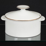 PORCELANA, uma (1) sopeira com tampa, ornamentação em barrado contínuo nas tonalidades preta e dourada,modelo MEDAILLON, manufatura RENNER (Porto Alegre, RS, fundada em 1942; em 1998 foi vendida para a VistaAlegre de Portugal; em 1999 mudou a razão social para Vista Alegre do Brasil), medindo 20,5 cm diâmetro mais asalças, sinais de uso, vide foto.