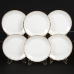 PORCELANA, seis (6) pratos rasos, ornamentação em barrado contínuo nas tonalidades preta e dourada, modeloMEDAILLON, manufatura RENNER (Porto Alegre, RS, fundada em 1942; em 1998 foi vendida para a Vista Alegre dePortugal; em 1999 mudou a razão social para Vista Alegre do Brasil), medindo 24,5 cm diâmetro, sinais de uso, videfoto.
