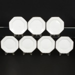 PORCELANA, sete (7) pratos para sobremesa, octogonais, arremates com frisos prateados, manufatura SCHMIDT(Pomerode, SC; Mauá, SP; Campo Largo, PR, fundada em 1945, ainda em atividade, maior fábrica de porcelana daAmérica Latina), um deles com bicado na borda, medindo 19 x 19 cm, sinais de uso, vide foto.