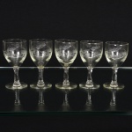 VIDRO, cinco (5) taças para licor, incolores e translúcidas, bojo com singela lapidação vegetalista, fuste cilíndrico,base em bolacha, medindo 9 cm altura, sinais de uso, vide foto.