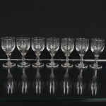 VIDRO, sete (7) taças para licor, incolores e translúcidas, bojo com singela lapidação vegetalista, fuste cilíndrico,base em bolacha, medindo 9 cm altura, sinais de uso, vide foto.