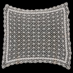 CAMA E MESA, uma (1) toalha quase quadrangular, confeccionada em crochê de linha branca, medindo 106 x 85cm, possui manchas, sinais de uso, vide foto.