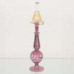 FLACON DE PARFUM, um (1) frasco vazio, veneziano, tonalidades roxo, incolor e amarelo, translúcido, singelalapidação vegetalista, arremates a ouro já com desgastes, medindo 19 cm altura, sinais de uso, vide foto.