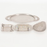 AÇO INOX, quatro (4) itens distintos: 1 saboneteira plissada com furos no fundo, medindo 12,5 x 8,5 cm; 1bandeja oval, alças relevadas em volutas, medindo 26,5 x 12,5 cm; 1 cinzeiro quadrangular, borda relevada em flores evolutas, lembrança de casa de Presentes  Duque de caxias, RJ, medindo 8 x 8 cm; 1 porta copo ou vela, formato deconcha, terminações em folhas, marca FRACALANZA (tradição desde 1884), medindo 13 x 9,5 cm, todos os itens comsinais de uso, vide foto.