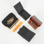 ACESSÓRIO FEMININO, cinco (5) itens: 1 bolsa de festa, falta a corrente da alça, confeccionada em tecido natonalidade preta, bordado floral policromado, monture em metal dourado, medindo 12,5 x 15,5 cm; 1 pente compropaganda da VARIG; 3 carteiras distintas, uma da marca RIDALMODA, uma em couro e tecido com bordado floral,uma de origem Suíça, todos os itens com sinais de uso, vide foto.