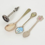 231) METAL PRATEADO, quatro (4) itens: 3 colheres distintas: uma concha para açucareiro, Made in England; umaesmaltada, souvenir de Portugal; uma com brasão de armas português; 1 miniatura da torre de televisão de Berlim,Alemanha, com a legenda 368M BERLIN 368M FERNSEHTURM, todos os itens com sinais de uso, vide foto.