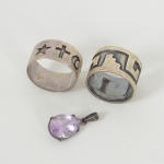 JOIAS, três (3) itens confeccionados em PRATA: 2 alianças, uma ornada em geométricos e outra com símbolos,ambas tamanho 17; 1 pingente com ametista, lapidação gota, medindo 1,5 cm, peso total aproximado 10,4 gr., vide foto.