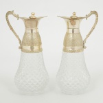 VIDRO, par (2) galhetas, incolores e translúcidas, modelagem dita bico de jaca, monture em metal prateado,medindo 14,5 cm altura, vide foto.