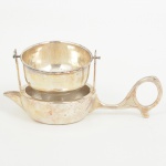 METAL PRATEADO, um (1) infusor de chá individual, manufatura EBERLE (Abramo Eberle 1880, Monte Magrè1945, Caxias do Sul, veio com uma das primeiras levas de imigrantes italianos para o Brasil em 1884 junto com seuspais Giuzeppe Eberle e Luigia Zanrosso, seu pai abriu uma pequena funilaria mas como tinha que trabalhar na lavouraquem cuidava era a mãe e o pequeno Abramo ajudava na funilaria; em 1896 quando o pai resolveu vender a funilariapara concentrar os esforços da família na lavoura Abramo, com 16 anos de idade, se propôs a comprá-la do pai, em 1918já com o nome Abramo Eberle & Cia iniciou a fabricação de talheres e utensílios de mesa, morreu em 1945 com 65 anosde idade e os filhos deram continuidade aos negócios até 1984 quando venderam para o Grupo Zivi), medindo 12 cmcomprimento, sinais de uso, vide foto.