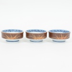 PORCELANA, três (3) pequenas tigelas acopláveis, ornamentação vegetalista nas tonalidades azul e marrom, semmarca de manufatura aparente, medindo 8 cm diâmetro, sinais de uso, vide foto.