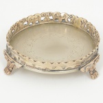 METAL PRATEADO, uma (1) pequena salva com fundo burilado, borda vazada em elementos vegetalistas, pésrelevados em elementos vegetalistas com terminações em garra, medindo 15,5 cm diâmetro, sinais de uso, vide foto.