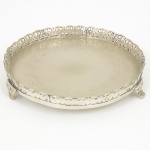 METAL PRATEADO, uma (1) pequena salva com fundo burilado, borda vazada em elementos vegetalistas, pésrelevados em elementos vegetalistas com terminações em garra, medindo 19,5 cm diâmetro, sinais de uso, vide foto.