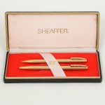 COLECIONISMO, conjunto com dois (2) itens: 1 caneta e 1 lapiseira, marca SHEAFFER, modeloINTERNACIONAL, douradas, acondicionadas na caixa original, falta a carga, sinais de uso, vide foto.