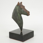 ESCULTURA, uma (1) equestre representando cabeça de cavalo, confeccionada em bronze, assinada P. THADEE,base em granito negro, medindo 18 cm altura, vide foto.