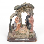 ARTE SACRA, um (1) grupo escultórico representando Menino Jesus, Maria e José, ladeados de vaca e cordeiro,possui perdas no telhado, confeccionada em resina policromada, placa metálica PIETRO DE SANTI, medindo 11 cmaltura, vide foto.