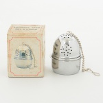 METAL PRATEADO, um (1) recipiente para infusão de chá, confeccionado em folha de flandres ou aço inox,TEA BALL WITH HOLDER, Made in China, acondicionado na caixa, não aparenta ter sido usado, medindo 5 cm maisa corrente, vide foto.