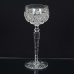 CRISTAL INGLÊS, uma (1) taça de pé alto para vinho, incolor e translúcida, bojo lapidado em palmas, sulcos eestrelas, fuste hexagonal no formato de balaustre com serrilhado, base em bolacha, fundo estrelado, manufatura daCristaleria STUART, modelo similar ao BACCARAT, medindo 20 cm altura, sinais de uso, vide foto.