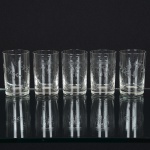 VIDRO, cinco (5) copos cilíndricos, incolores e translúcidos: 2 com singela lapidação vegetalista; 3 ornados combarrado contínuo, manufatura FRATELLI VITA (fábrica de cristais fundada em 1902, pelos irmãos Giuseppe Vita eFrancesco Vita, na cidade de Salvador na Bahia, no início como fábrica de licores, vinhos e refrigerantes, mais tardecom as dificuldades em importar as garrafas devido a Primeira Grande Guerra Mundial, passou a fabricar os própriosengradados, a partir de 1920 aventurou-se na produção de cristais recebendo diversas premiações em exposiçõesinternacionais, na década de 50 no apogeu da fabrica, financiou o trio elétrico de Dodô e Osmar em 1951 e acandidatura de Martha Rocha para Miss Brasil em 1954, que virou garota propaganda da fabrica, com a transferência dacapital do Brasil do Rio de janeiro para Brasília, a Primeira Dama Sara Kubitschek, encomendou um jogo de taças como Brasão da república impresso a ouro, a fabrica fechou em 1962), todos medindo aproximadamente 8,5 cm altura e 5cm diâmetro, sinais de uso, vide foto.