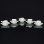 PORCELANA PORTUGUESA, cinco (5) xícaras para café, modeladas em suaves caneluras, faixas nastonalidades cinza, preto e dourado, manufatura VISTA ALEGRE (fundada em 1824, pelo negociante, lavrador,industrial e político, José Ferreira Pinto Basto, através de alvará concedido por D. João VI, tendo seu fundadorassociado a fábrica os seus 15 filhos, ficando a sociedade denominada Ferreira Pinto & Filhos; cinco anos mais tarderecebe o título real pelo reconhecimento de sua arte e sucesso, ficando conhecida como Real Fábrica da Vista Alegre,começou no fabrico de vidros enquanto se empenhava em esforços para a produção de porcelana, os primeiros ensaiosconseguidos foram imperfeitos denominado loiça de pó de pedra, através de boas relações com a fábrica francesa deSevres conseguiu as receitas para o fabrico de porcelana, somente em 1832, por sorte, é encontrado um jazigo de caulimsituado em Aveiro, próximo a Ílhavo, a partir desta data o fabrico de porcelana foi se aperfeiçoando em Portugal, 1851expôs com sucesso no Palácio de Cristal em Londres; 1852 D. Fernando II visita a fábrica e encomenda uma baixelacompleta; 1867 recebeu sua primeira premiação na Exposição Universal de Paris; 1880 interrompe a produção de vidrospara se dedicar exclusivamente a porcelana; 1964 inauguração do Museu Histórico da Vista Alegre; ainda emfuncionamento), vide foto.