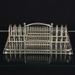 METAL PRATEADO, um (1) organizador de talheres, confeccionado em tubo ou aramado vergado, placa emacrílico, incolor e translúcida, arremates em esferas, marca RIVA, medindo 27,5 x 22 cm, sinais de uso, vide foto.