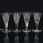 CRISTAL INGLÊS, quatro (4) taças de pé alto para drinque, incolores e translúcidas, bojo obcônico lapidado emsulcos e dedão, continuação do fuste hexagonal, base em bolacha, manufatura da Cristaleria STUART, modelo similarao BACCARAT, medindo 11 cm altura, sinais de uso, vide foto.