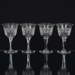 CRISTAL INGLÊS, quatro (4) taças de pé alto, incolores e translúcidas, bojo lapidado em sulcos e dedão, fustehexagonal, base em bolacha, manufatura da Cristaleria STUART, modelo similar ao BACCARAT, medindo 12 cmaltura, sinais de uso, vide foto.