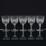 CRISTAL INGLÊS, cinco (5) taças de pé alto, incolores e translúcidas, bojo lapidado em sulcos e dedão, fustehexagonal, base em bolacha, manufatura da Cristaleria STUART, modelo similar ao BACCARAT, medindo 15 cmaltura, sinais de uso, vide foto.