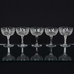 CRISTAL INGLÊS, cinco (5) taças de pé alto para champanhe ou espumante, incolores e translúcidas, bojolapidado em sulcos e dedão, fuste hexagonal, base em bolacha, manufatura da Cristaleria STUART, modelo similar aoBACCARAT, medindo 11,5 cm altura, sinais de uso, vide foto.