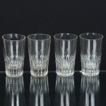 DEMI CRISTAL, quatro (4) copos, incolores e translúcidos, quase cilíndricos, metade inferior canelada na vertical,medindo 5 cm diâmetro e 9 cm altura, sinais de uso, vide foto.