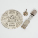 ARTE SACRA, três (3) itens: 1 imaginária de Santa Terezinha, confeccionada em alumínio, acondicionada noestojo em folha de flandres, medindo 2,5 cm altura; 1 medalha representando a aparição de Nossa Senhora de Fátima,confeccionada em metal prateado, medindo 1,4 cm mais olhal e argola; 1 placa uniface, lembrança do XXXII CongressoEucarístico Internacional, realizado em Buenos Aires, Argentina no ano de 1934, confeccionada em metal prateado,medindo 6 cm diâmetro, vide foto.